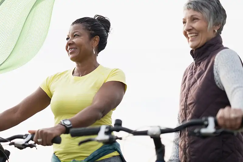 Two women having a great time on a bike ride not worrying about bladder issues thanks to Axonics Therapy.